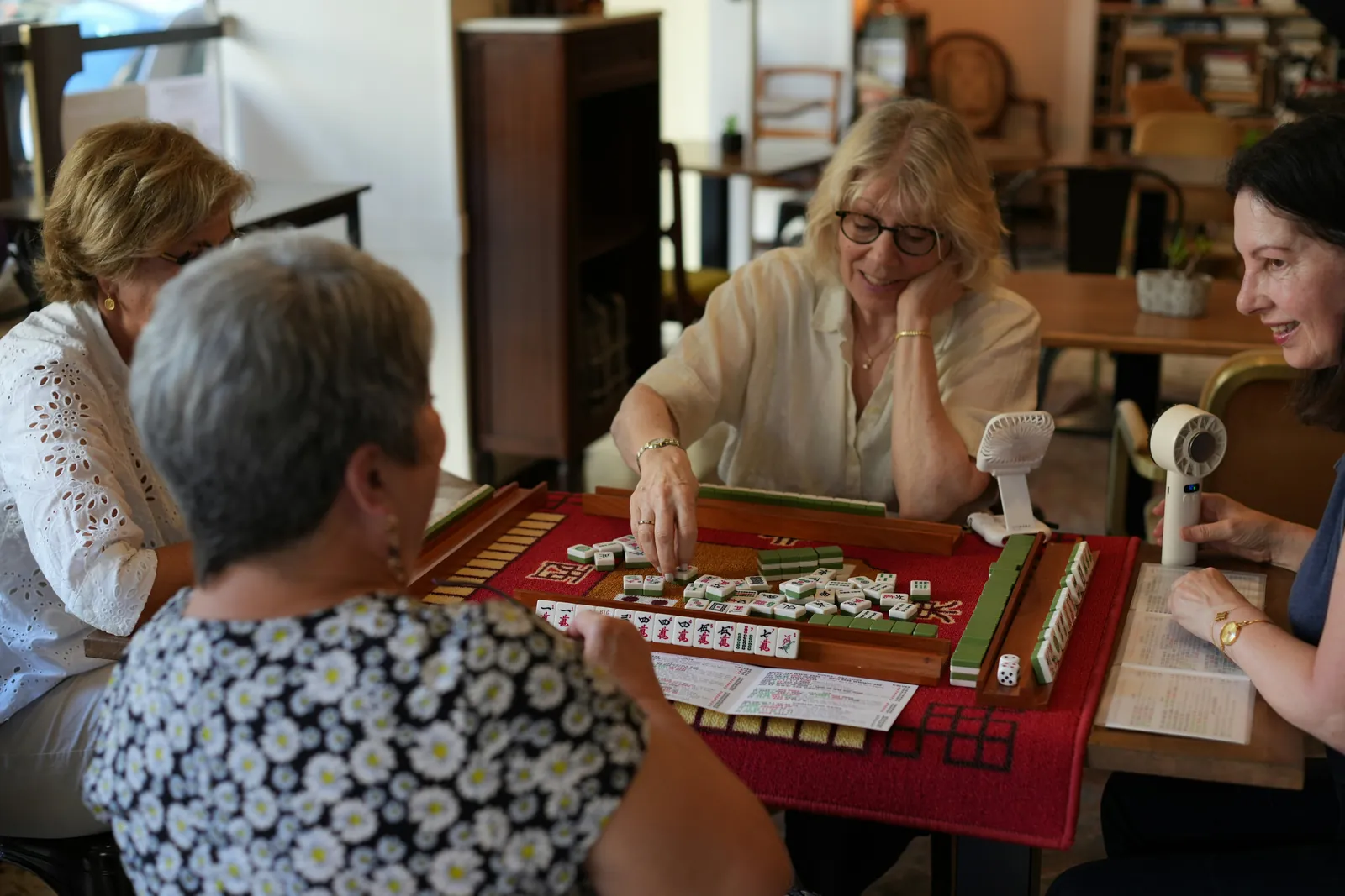 A group of adults enjoying a Mahjong game together